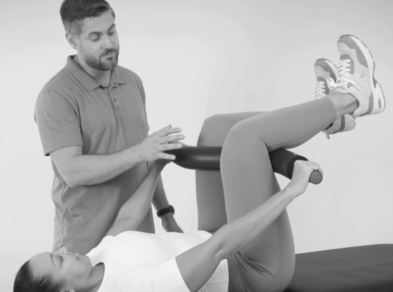 Physical Therapist assisting the patient in using the ProStretch Z for lower back pain relief.