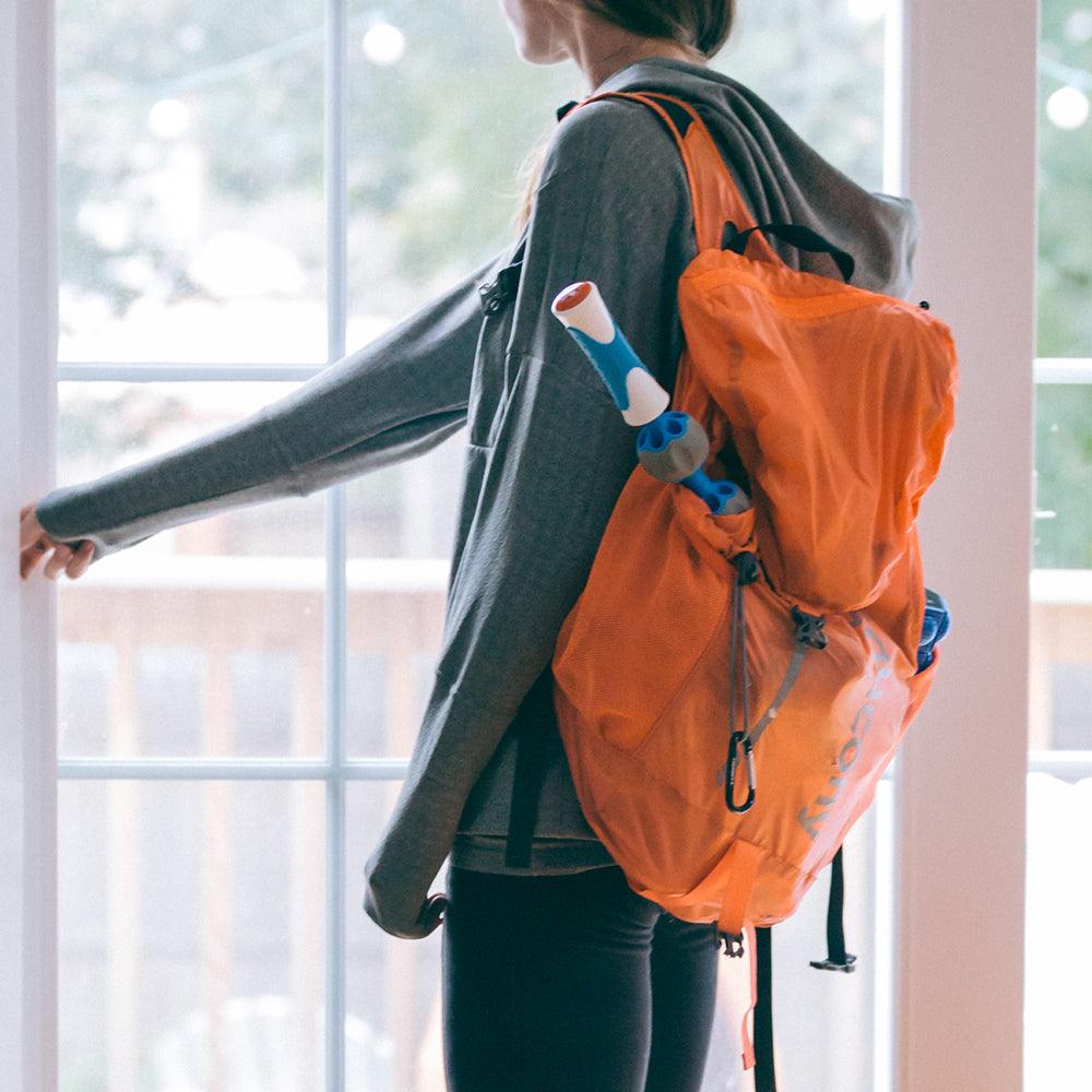 Lady carrying the Pro Roller massage stick in her back pack.