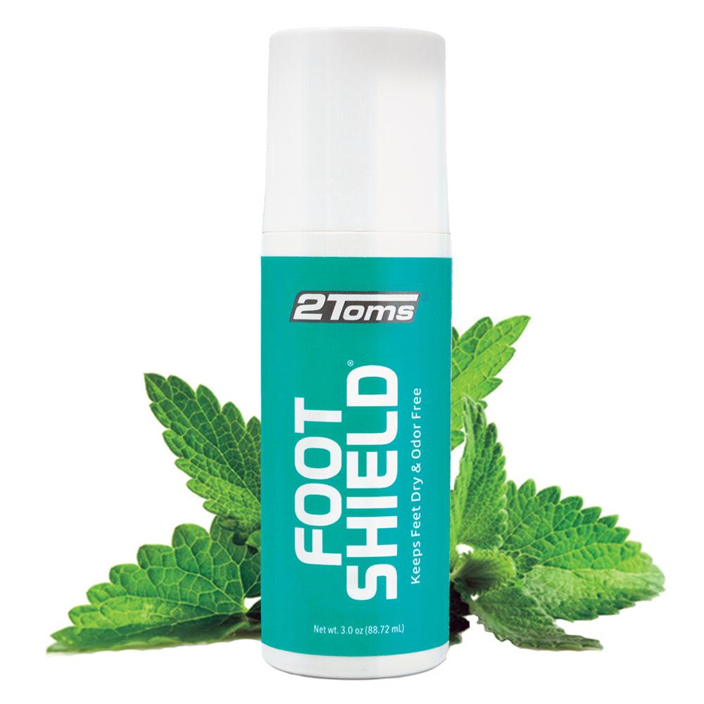 Bottle of 2Toms FootShield with mint leaves behind it.