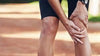 Male runner putting pressure on knee with hands