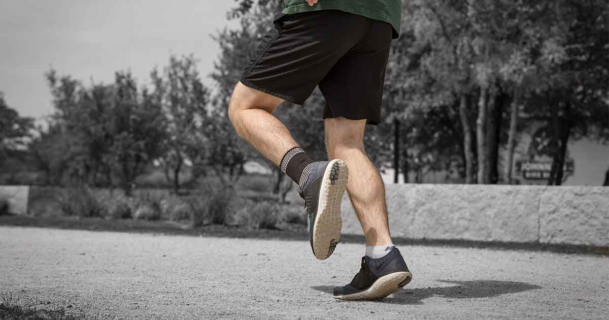 Man running at the park wearing an ankle compression sleeve