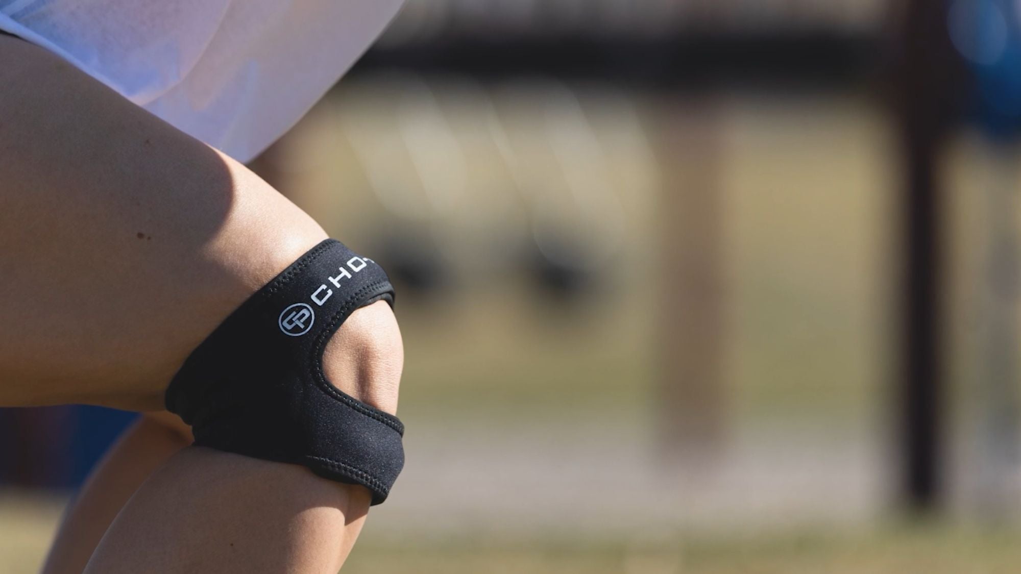 Close-up of Cho-Pat Dual Action Lite knee strap worn on knee outdoors